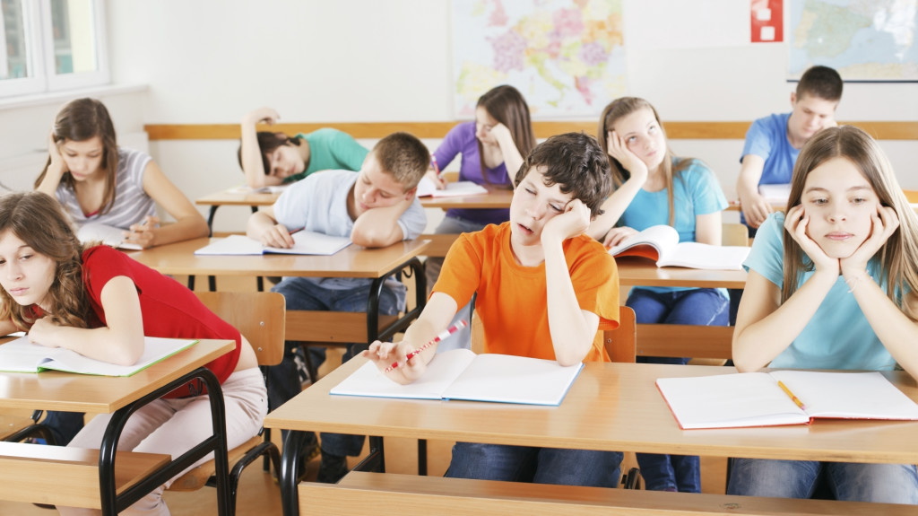 Group of bored pupils in a classroom, during lesson.